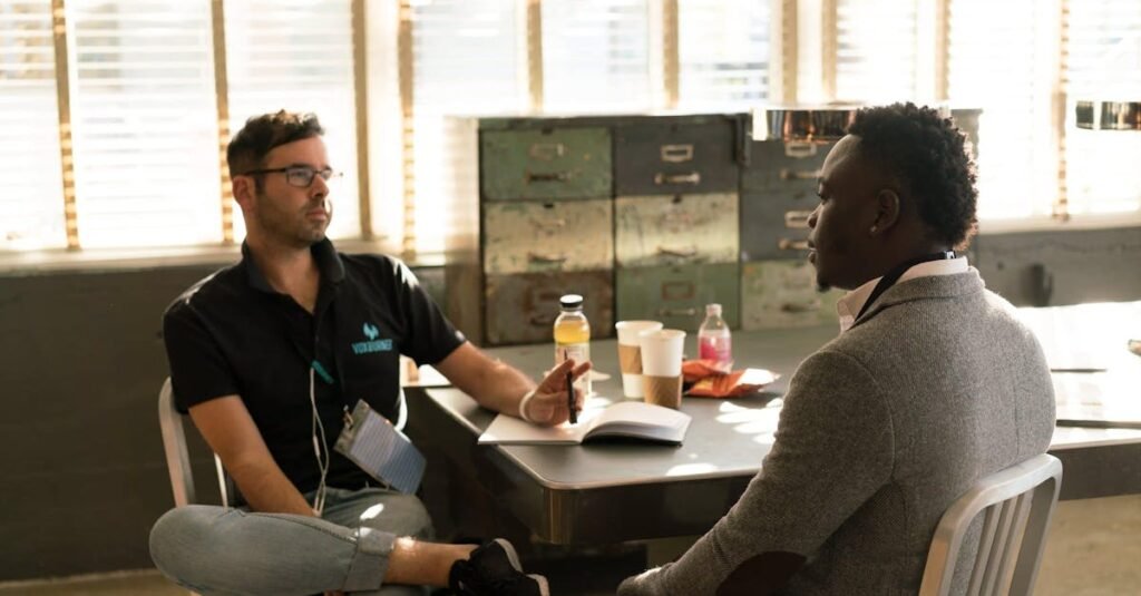 Two men having a focused business discussion in a sunlit office space.
